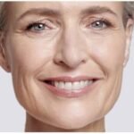 Mulher madura sorrindo com pele saudável e firme, representando resultados de cremes anti-idade eficazes.