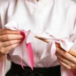 Mulher fazendo laços sem ferramenta com fita rosa usando técnica manual profissional